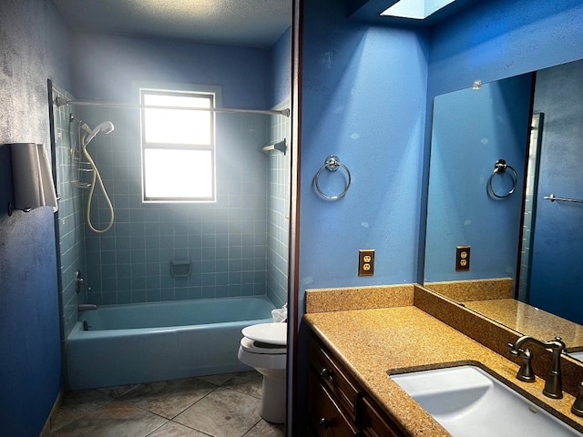 full bathroom with tile patterned flooring, tiled shower / bath, a textured ceiling, toilet, and vanity