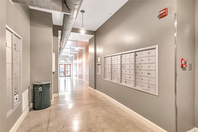 hallway featuring a towering ceiling and mail boxes