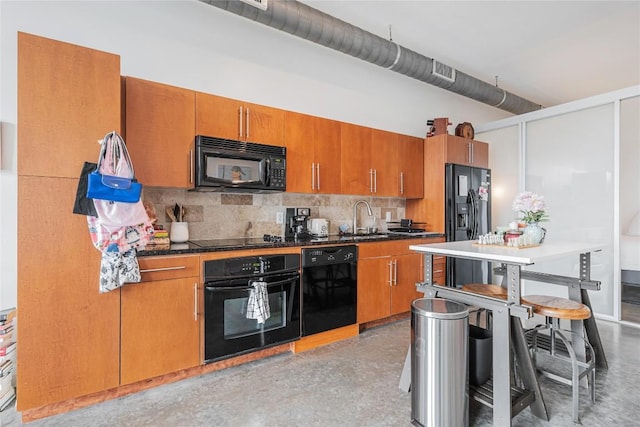 2124 E 6th St Unit 305, Austin, TX 78702 - kitchen featuring black appliances, brown cabinetry, tasteful backsplash, a sink, and dark countertops