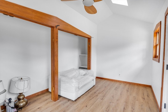 unfurnished room featuring light hardwood / wood-style flooring, lofted ceiling with skylight, and ceiling fan