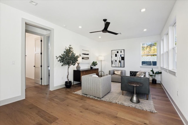 living room with dark wood-type flooring and ceiling fan