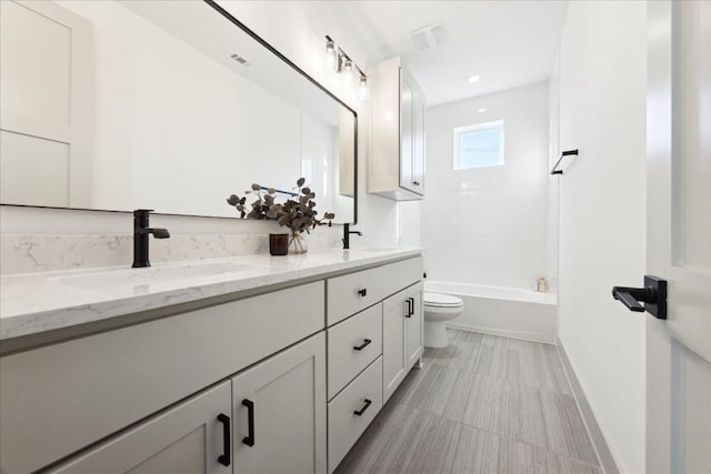 full bathroom featuring tiled shower / bath, vanity, and toilet