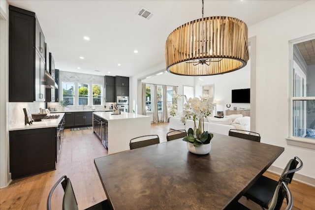 3001 Funston St, Austin, TX 78703 - dining space with light wood-style floors, a chandelier, and recessed lighting