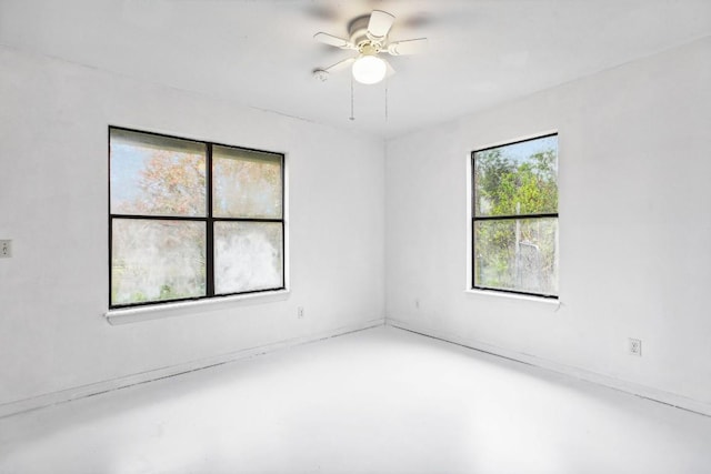 empty room with ceiling fan and concrete flooring