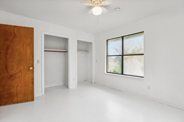 unfurnished bedroom featuring multiple closets and ceiling fan