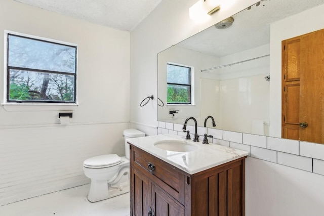 bathroom featuring vanity, a textured ceiling, and toilet