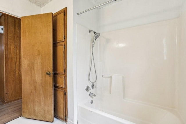 bathroom with hardwood / wood-style floors and bathtub / shower combination