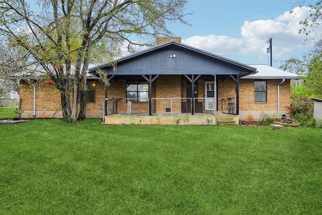 back of house featuring a yard and covered porch