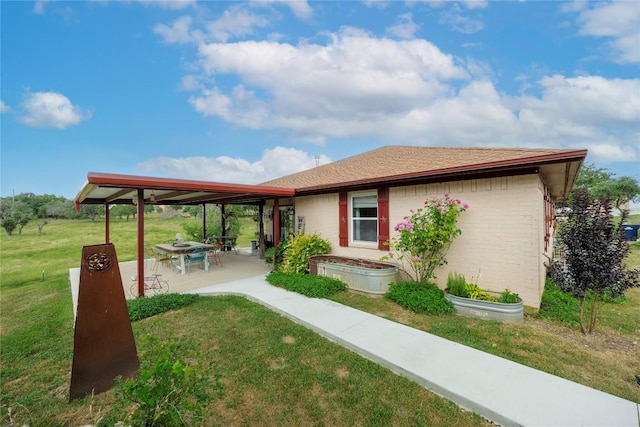 rear view of property featuring a patio area and a lawn