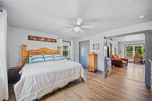 bedroom featuring multiple windows, ceiling fan, and wood-type flooring