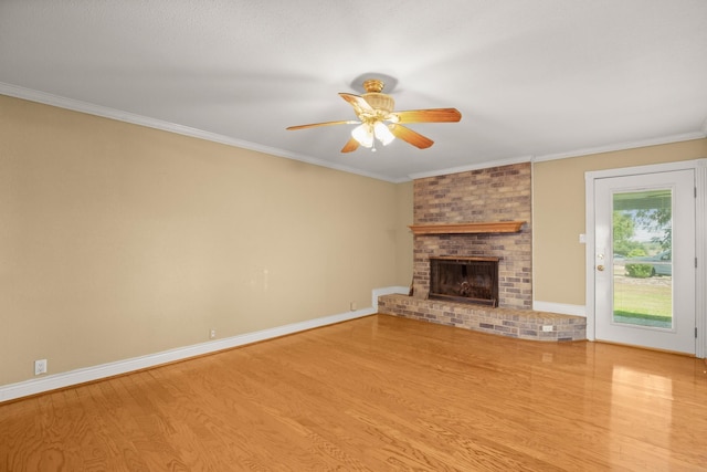 unfurnished living room with a brick fireplace, ornamental molding, light hardwood / wood-style floors, and ceiling fan