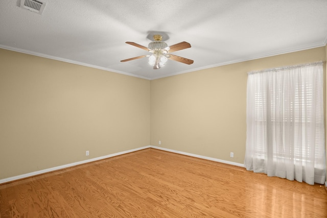 spare room featuring a textured ceiling, light hardwood / wood-style flooring, ornamental molding, and ceiling fan