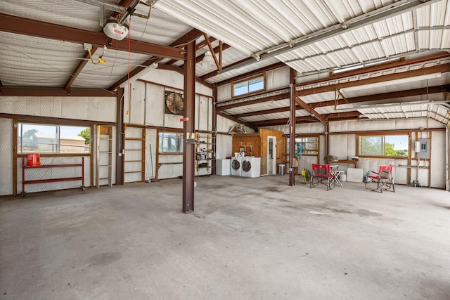 garage featuring a garage door opener, washer and clothes dryer, and electric panel