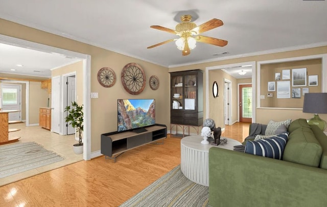 8712 Cele Rd Unit 1, Manor, TX 78653 - living room featuring crown molding, plenty of natural light, a ceiling fan, light wood-style flooring, and baseboards