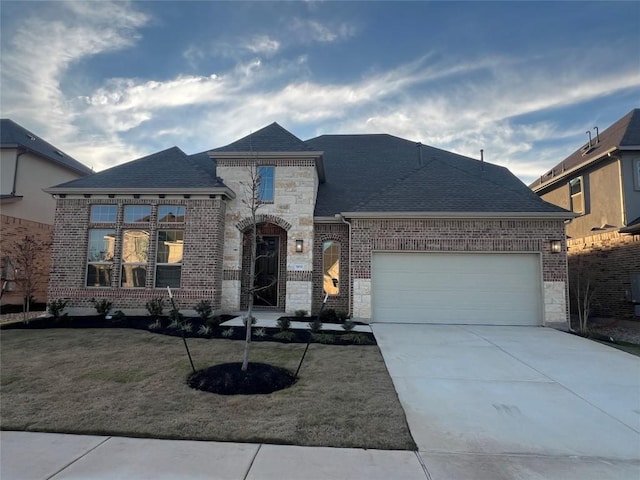 french country home featuring a garage and a front yard