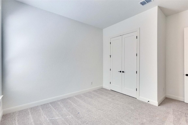 unfurnished bedroom with visible vents, baseboards, carpet, and a closet