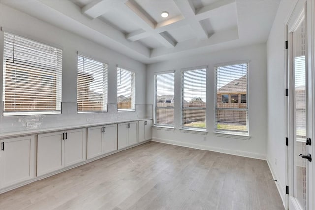 unfurnished sunroom with beam ceiling and coffered ceiling