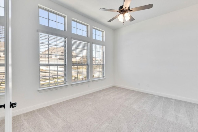 carpeted empty room featuring baseboards and ceiling fan