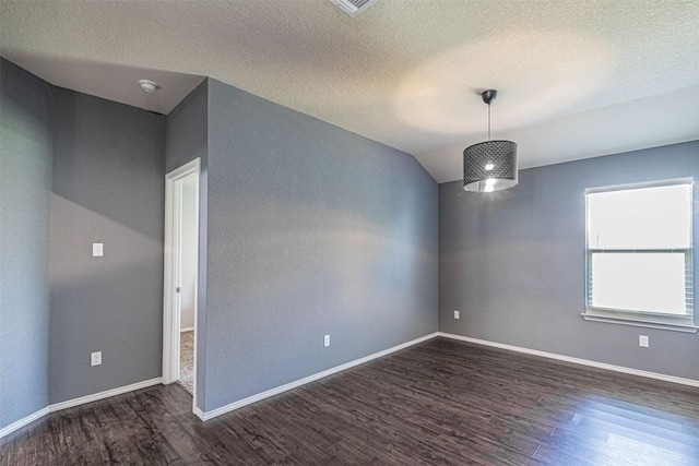 empty room with a textured ceiling and dark wood-type flooring