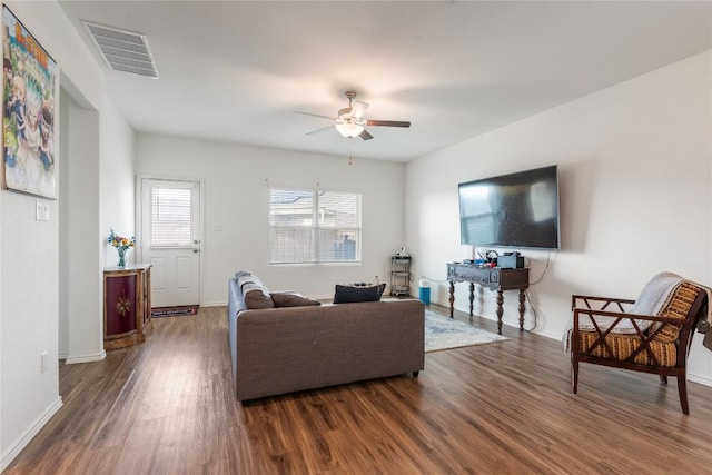 living room with ceiling fan and dark wood-type flooring