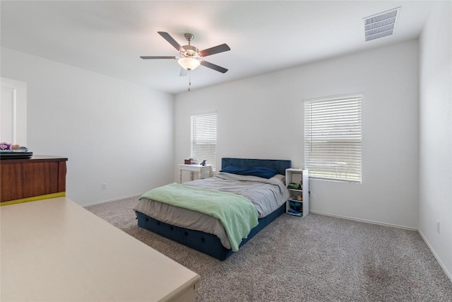 carpeted bedroom featuring ceiling fan and multiple windows