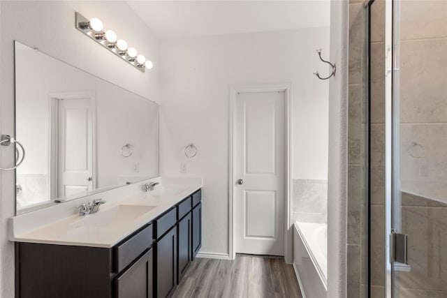 bathroom with vanity, hardwood / wood-style flooring, and independent shower and bath