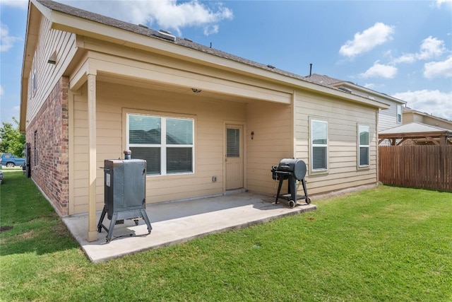 rear view of house featuring a yard and a patio