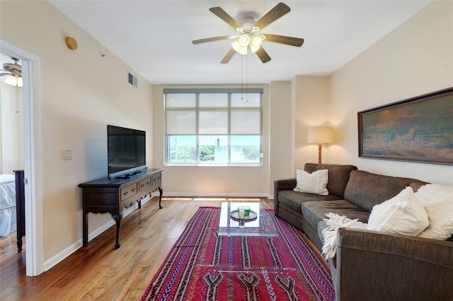 living room featuring ceiling fan and hardwood / wood-style floors