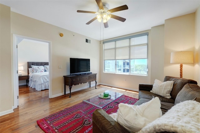 living room with light wood-type flooring and ceiling fan