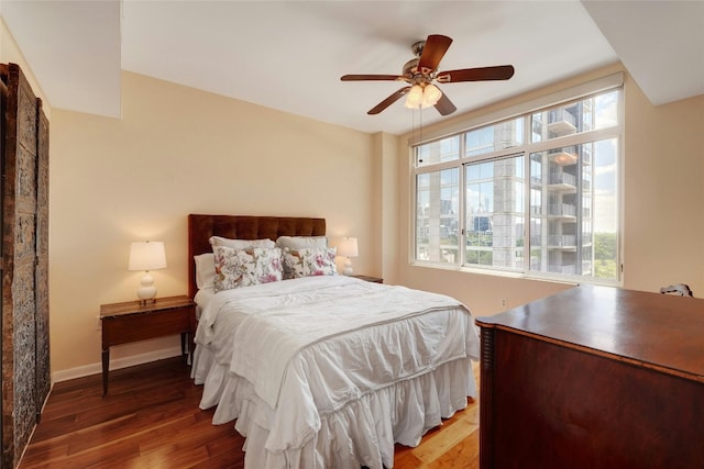 bedroom with multiple windows, hardwood / wood-style floors, and ceiling fan