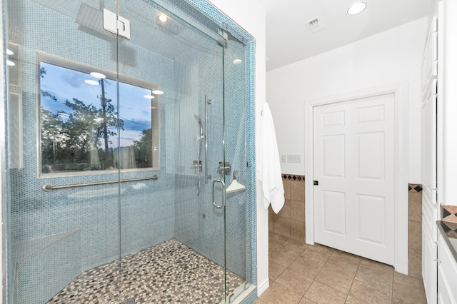 bathroom featuring a shower with door, vanity, and tile patterned floors