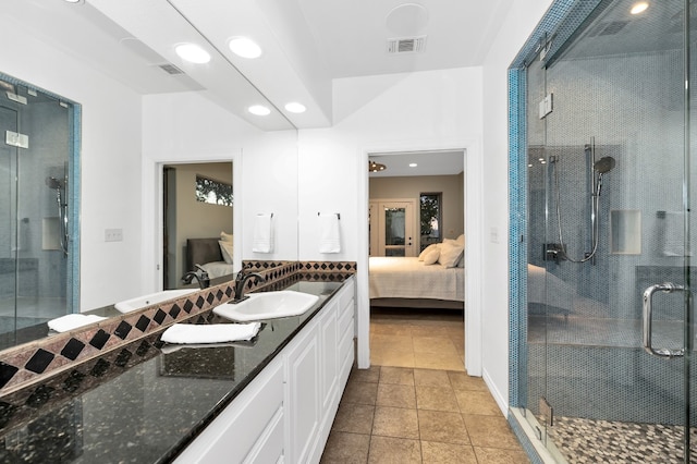 bathroom featuring tile patterned floors, a shower with shower door, and vanity