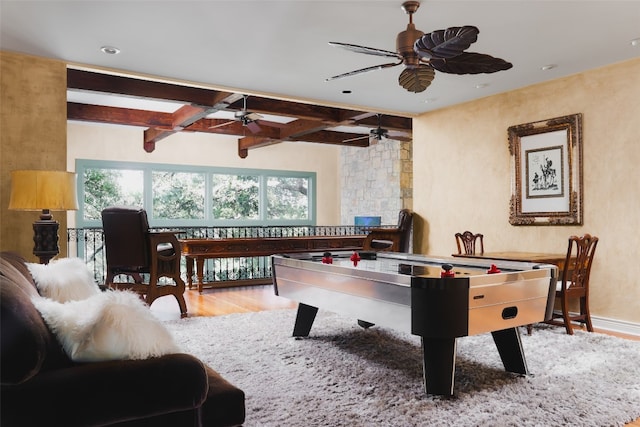 rec room featuring ceiling fan, beamed ceiling, hardwood / wood-style flooring, and coffered ceiling