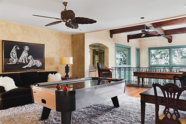 recreation room with ceiling fan, hardwood / wood-style floors, and beam ceiling