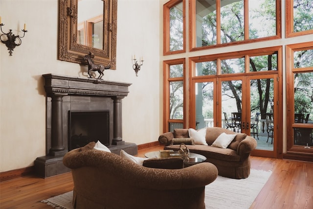 living room with french doors, hardwood / wood-style flooring, and a towering ceiling