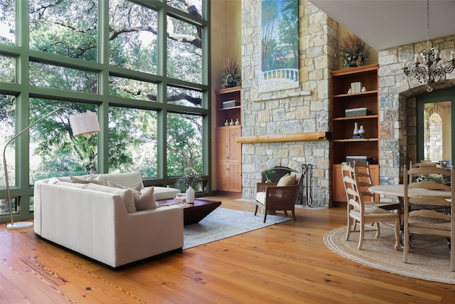 living room with a fireplace, wood-type flooring, and a towering ceiling