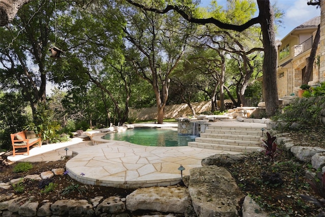 view of pool with a patio area and pool water feature