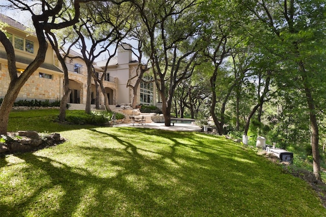 view of yard featuring a patio and a balcony