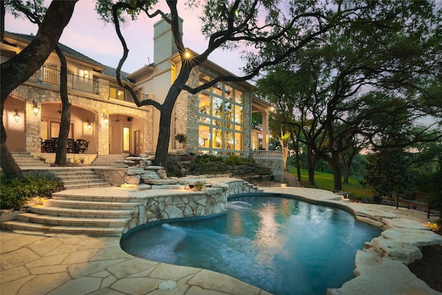 pool at dusk with a patio