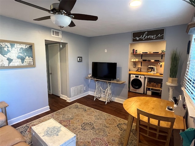 living room featuring washer / clothes dryer, dark hardwood / wood-style floors, and ceiling fan