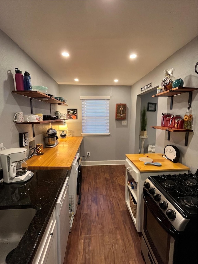 kitchen with dark wood-type flooring, wood counters, stainless steel range with gas stovetop, and white dishwasher