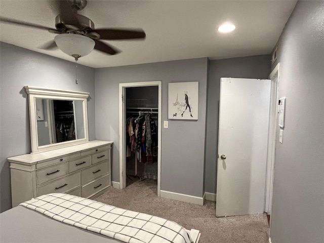 carpeted bedroom with a closet, ceiling fan, and a spacious closet