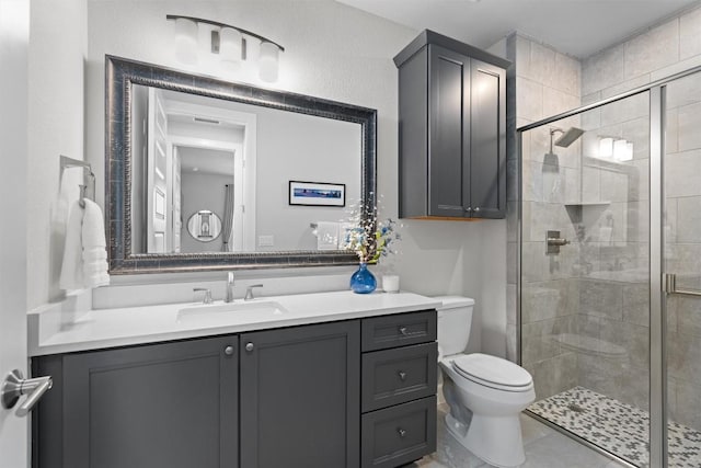 bathroom featuring tile patterned floors, vanity, toilet, and walk in shower