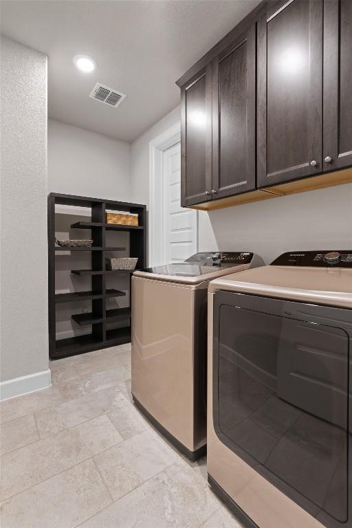 laundry area featuring separate washer and dryer and cabinets