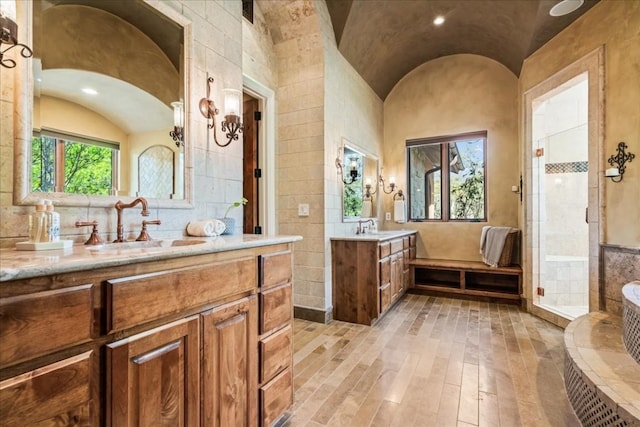 bathroom with vaulted ceiling, separate shower and tub, and vanity