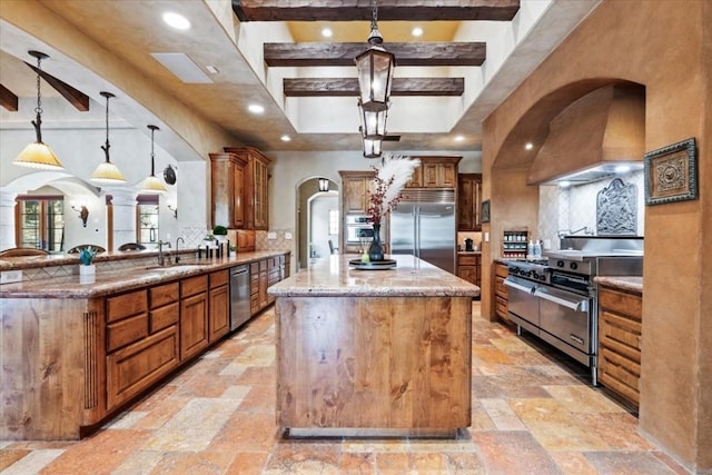 kitchen featuring a spacious island, high end appliances, backsplash, and pendant lighting