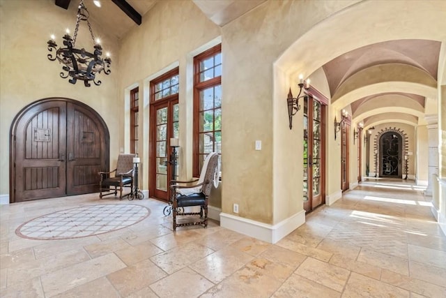 foyer entrance with high vaulted ceiling, french doors, and beamed ceiling