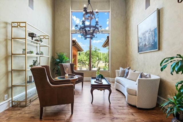 living area featuring an inviting chandelier and wood-type flooring