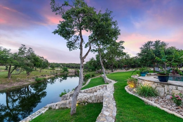 surrounding community with a lawn and a water view