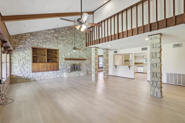 unfurnished living room featuring a textured ceiling, ceiling fan, a stone fireplace, wood-type flooring, and high vaulted ceiling